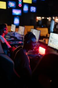 A group of diverse gamers immersed in gameplay at an internet cafe with colorful screens.